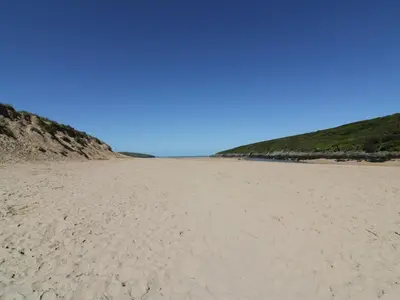 a sandy beach with footprints in the sand at Great Western Farmhouse in Newquay