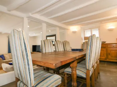 a dining room with a wooden table and chairs at Great Western Farmhouse in Newquay