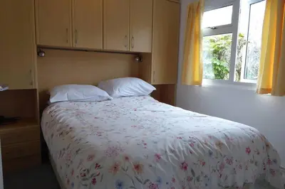 a bedroom with a bed with two pillows and a window at Rostowan Villa, very near the Beach in Truro