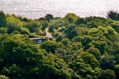 a house in the middle of a forest next to the water at Rostowan Villa, very near the Beach in Truro