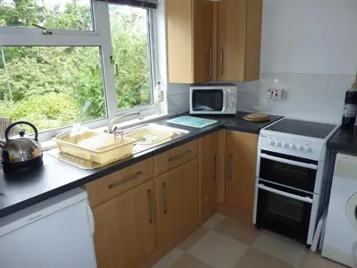 a kitchen with a sink and a stove and a window at Rostowan Villa, very near the Beach in Truro