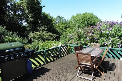 a grill and a table and chairs on a deck at Rostowan Villa, very near the Beach in Truro
