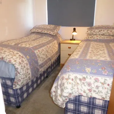 a bedroom with two beds and a night stand at Rostowan Villa, very near the Beach in Truro