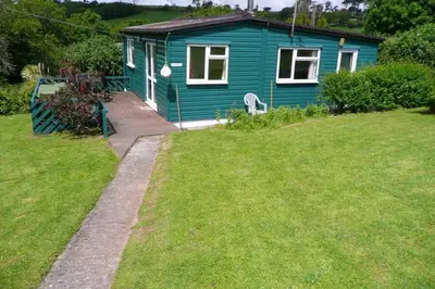 a blue house in a yard with a grass field at Rostowan Villa, very near the Beach in Truro