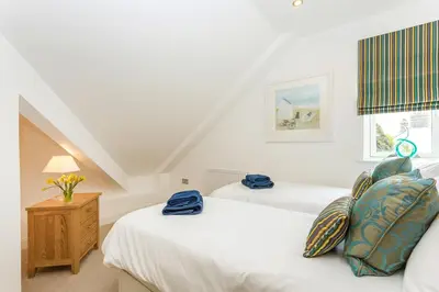 a bedroom with two beds and a window at Apartment by the beach, sea views in St Merryn