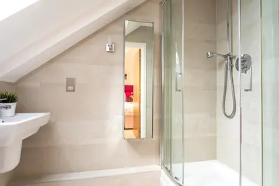 a bathroom with a shower and a sink at Apartment by the beach, sea views in St Merryn