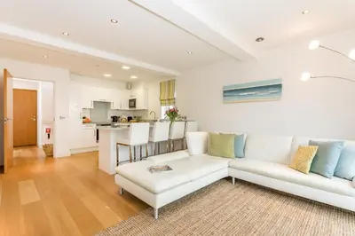 a living room with a white couch and a table at Apartment by the beach, sea views in St Merryn
