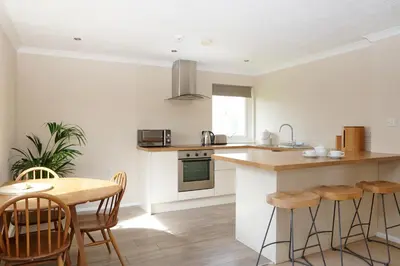 a kitchen with a counter and a table and chairs at Gwithian Holidays in Hayle
