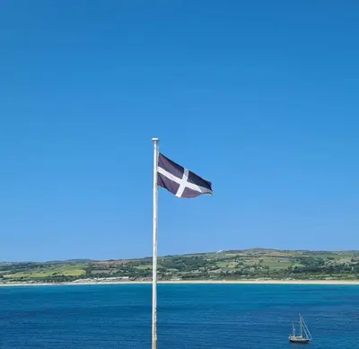 a flag on a pole in front of a body of water at Detached Bungalow in North Cornwall in Bodmin