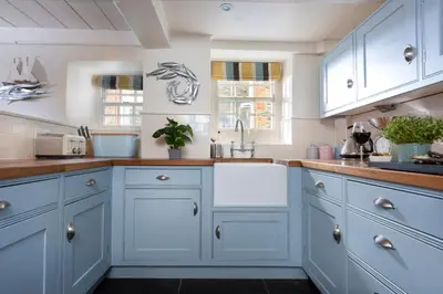 a kitchen with blue cabinets and a sink at Navas Nook in Falmouth