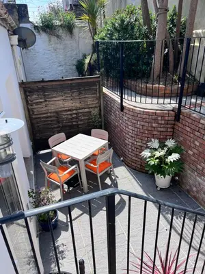 a patio with a table and chairs on a balcony at Bank Place in Falmouth