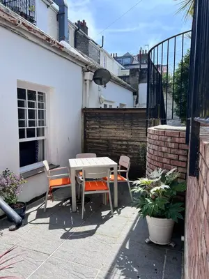 a patio with a table and chairs in front of a building at Bank Place in Falmouth