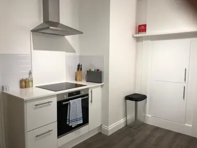 a kitchen with white cabinets and a stove top oven at Bank Place in Falmouth
