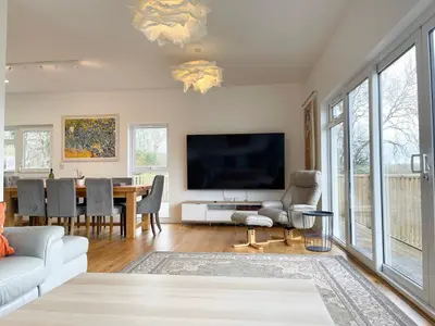 a living room with a large tv and a table at Woodhall in Bodmin