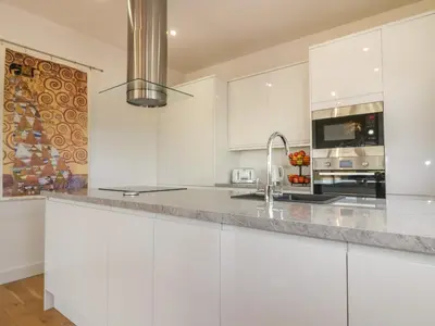 a white kitchen with white cabinets and a sink at Woodhall in Bodmin