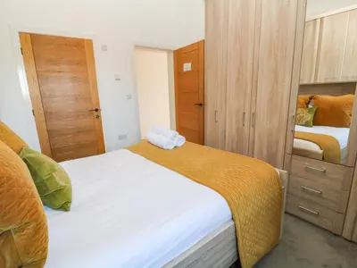 a small bedroom with two beds and a closet at Woodhall in Bodmin