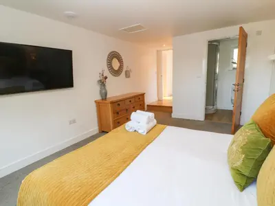 a bedroom with a large bed and a flat screen tv at Woodhall in Bodmin