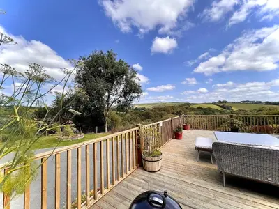 a wooden deck with a table and chairs on it at Woodhall in Bodmin