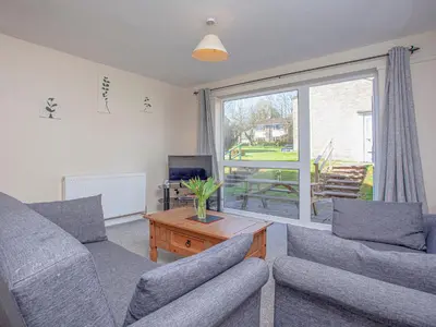 a living room with a couch and a table and a window at 117 Atlantic Reach-Uk32918 in Saint Columb Major