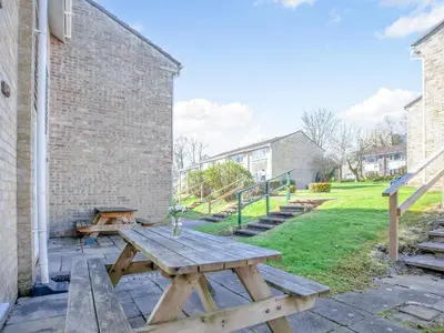 a wooden picnic table sitting next to a brick wall at 117 Atlantic Reach-Uk32918 in Saint Columb Major