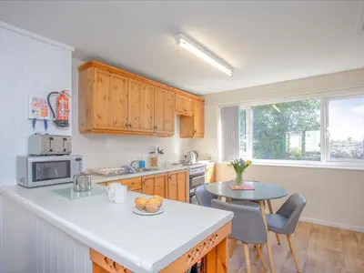 a kitchen with a counter and a table with chairs at 117 Atlantic Reach-Uk32918 in Saint Columb Major
