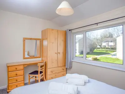 a bedroom with a bed and a desk and a window at 117 Atlantic Reach-Uk32918 in Saint Columb Major