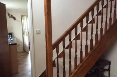 a wooden staircase in a room with a hallway at Okewoon Farm in Lanivet