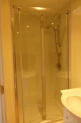 a glass shower in a bathroom next to a sink at Okewoon Barn in Lanivet