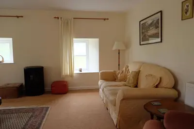 a living room with a couch and a window at Okewoon Barn in Lanivet