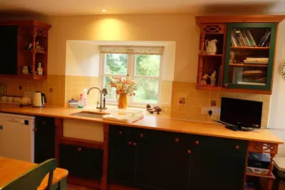 a kitchen with a counter with a sink and a window at Okewoon Barn in Lanivet