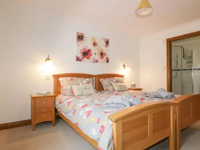 a bedroom with a bed with a wooden bed frame at Meadowside in Truro