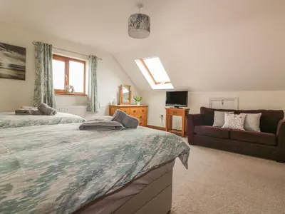 a bedroom with two beds and a couch at Meadowside in Truro