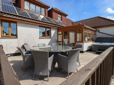 a patio with a table and chairs and a grill at Meadowside in Truro