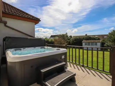 a hot tub on a patio with a fence at Meadowside in Truro