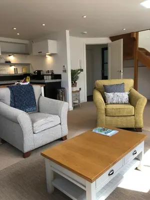 a living room with two chairs and a coffee table at The Old English Rooms in Falmouth