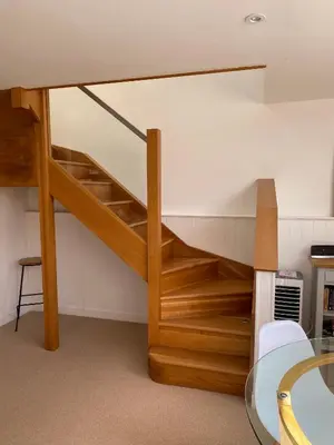 a loft bed with wooden stairs in a room at The Old English Rooms in Falmouth