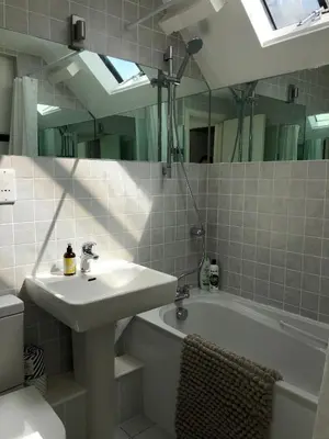 a bathroom with a sink and a tub and a mirror at The Old English Rooms in Falmouth
