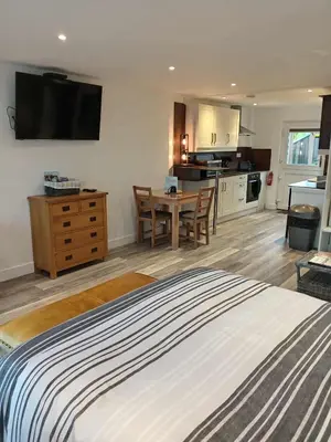 a bedroom with a bed and a kitchen with a table at 43 annexe in Newquay