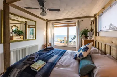 a bedroom with a bed with a view of the ocean at 1 Bed Flat - Sleeps 2 - Pets - Balcony - Parking in Looe