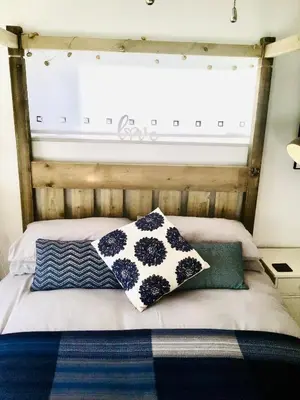 a bed with pillows on it with a window at 1 Bed Flat - Sleeps 2 - Pets - Balcony - Parking in Looe
