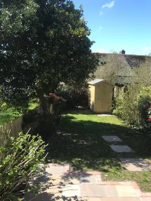 a garden with a tree in the middle of a yard at Frogmore Corner in Tregoney
