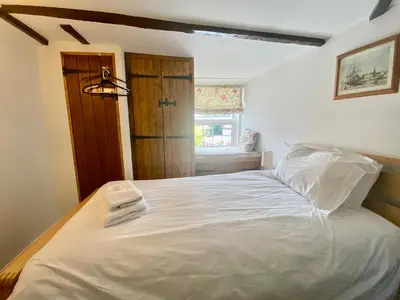 a bedroom with a white bed with two towels on it at Frogmore Corner in Tregoney