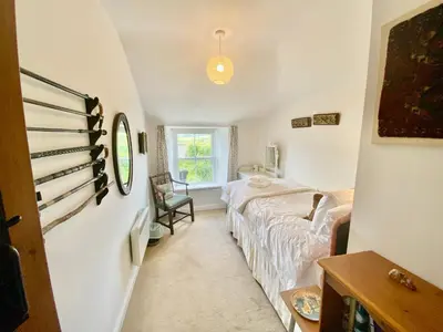 a bedroom with a bed and a window at Frogmore Corner in Tregoney