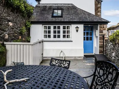 a table and chairs in front of a cottage at The Old Store House in Boscastle