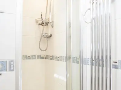 a bathroom with a shower with a glass door at The Old Store House in Boscastle