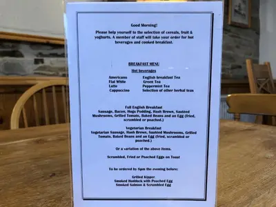 a menu for a restaurant on a sign on a table at The Galleon Inn in Fowey