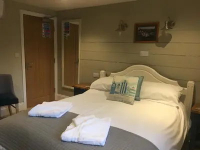 a bedroom with a bed with two towels on it at The Galleon Inn in Fowey