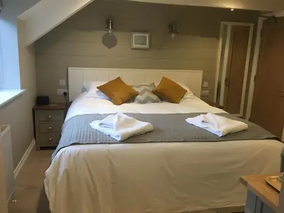 a bedroom with a large bed with two towels on it at The Galleon Inn in Fowey