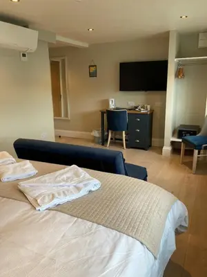 a bedroom with a bed with a tv on the wall at The Galleon Inn in Fowey