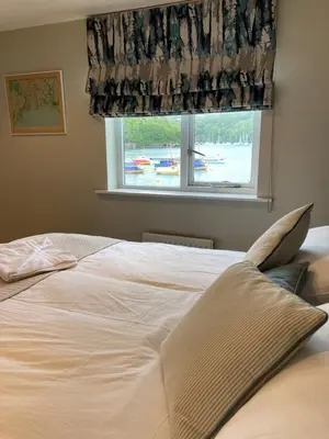 a large white bed in a bedroom with a window at The Galleon Inn in Fowey